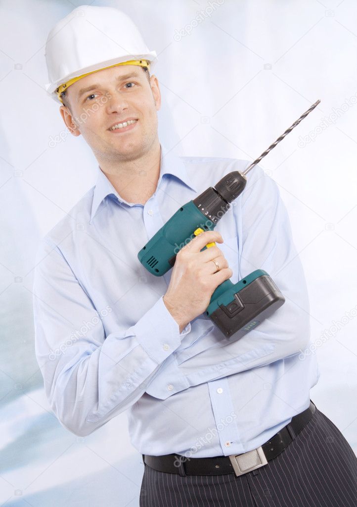Full length of successful business man with cordless drill