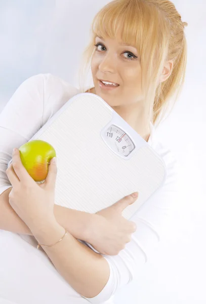 Closeup portrait of a happy woman with apple and scales — Stock Photo, Image