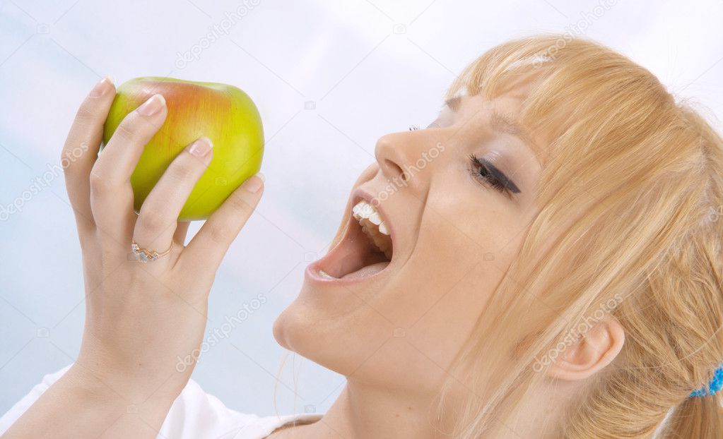 Closeup portrait of a happy young woman with an apple