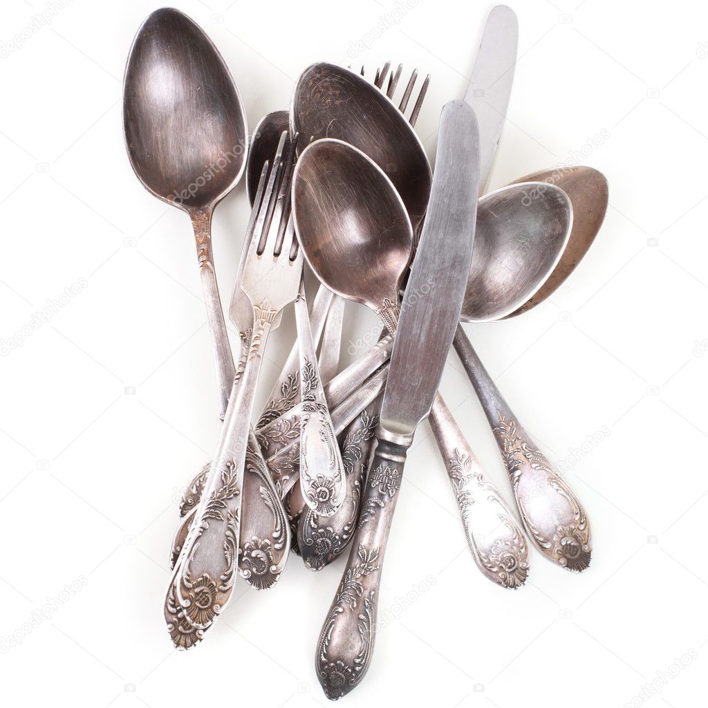 Silver spoons, forks and knifes isolated over white