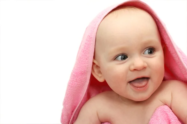 Sorrindo bebê pequeno envolto em uma toalha rosa no fundo branco — Fotografia de Stock