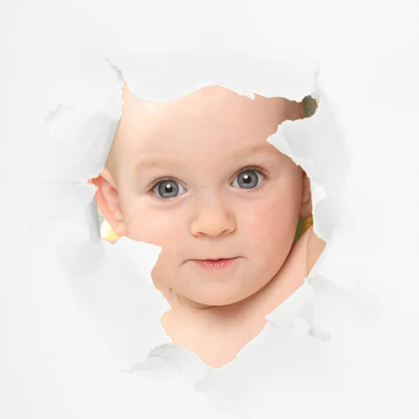 Cute baby looking through paper hole — Stock Photo, Image