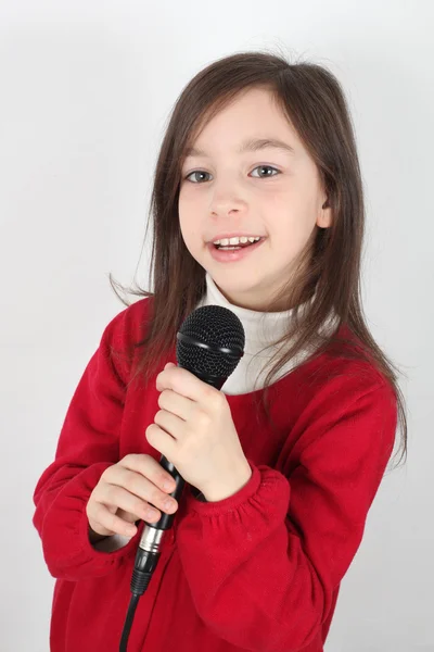 Menina está cantando com um microfone — Fotografia de Stock