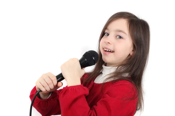 Całkiem mała dziewczynka śpiewa w mikrofon na białym tle nad białym — Zdjęcie stockowe