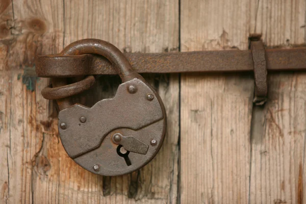Cadeado enferrujado em uma porta velha — Fotografia de Stock
