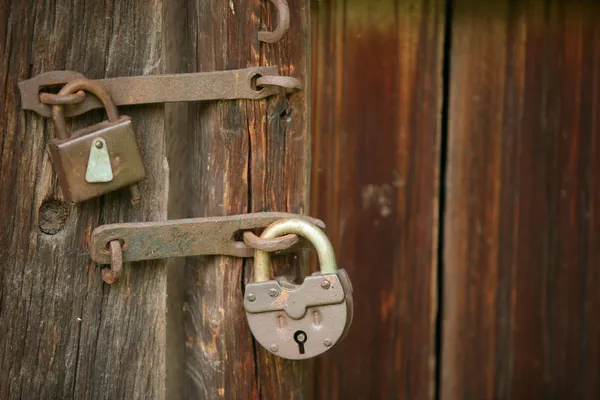 Dois cadeados enferrujados em uma porta velha — Fotografia de Stock