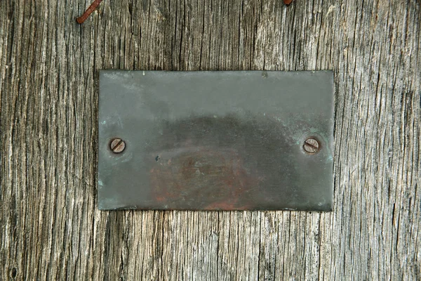 Metal shield on timber wall — Stock Photo, Image