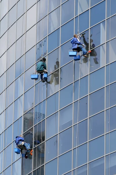 Lavadoras de janelas em um prédio de escritórios no centro da cidade — Fotografia de Stock