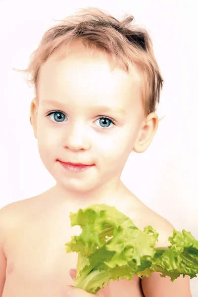 Petite fille tenant une feuille de salade de laitue — Photo