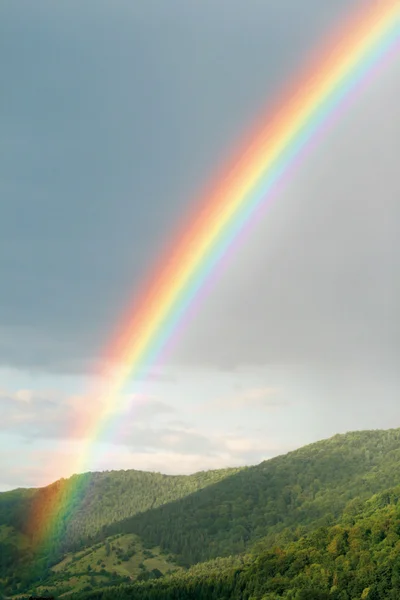 Rainbow over green hills Royalty Free Stock Photos