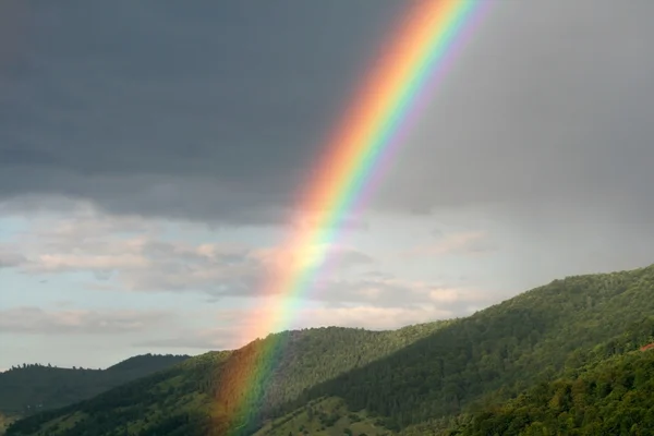 Rainbow in mountains Stock Image
