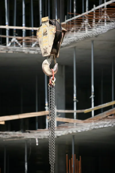 Шкив, крюк и цепь на строительной площадке — стоковое фото