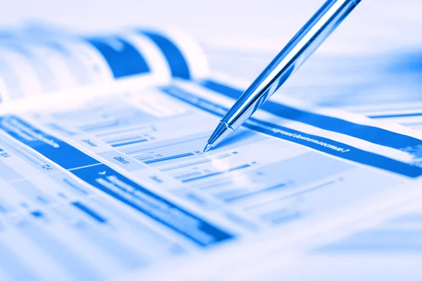 Pen showing diagram on financial magazines — Stock Photo, Image