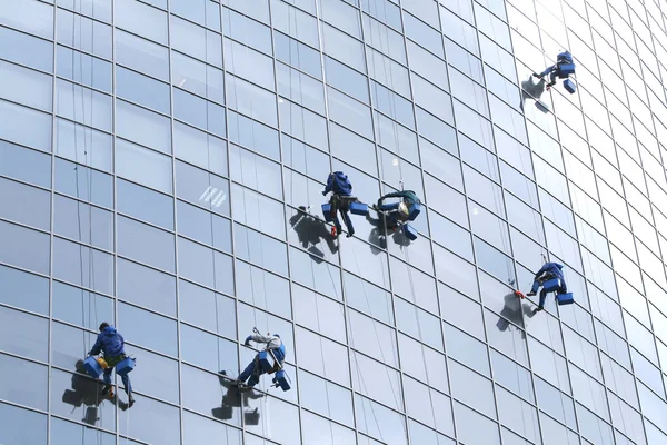 Ouvriers lavant les fenêtres dans l'immeuble de bureaux — Photo