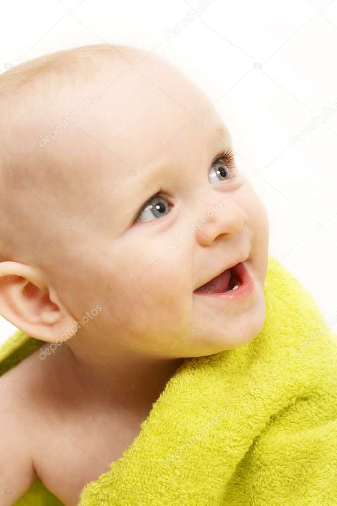 Smiling baby wrapped in a green towel on white background
