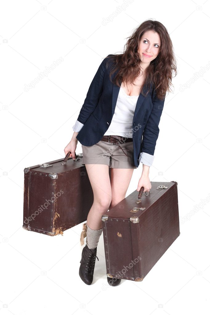 Young attractive girl is walking with two heavy vintage cases. S