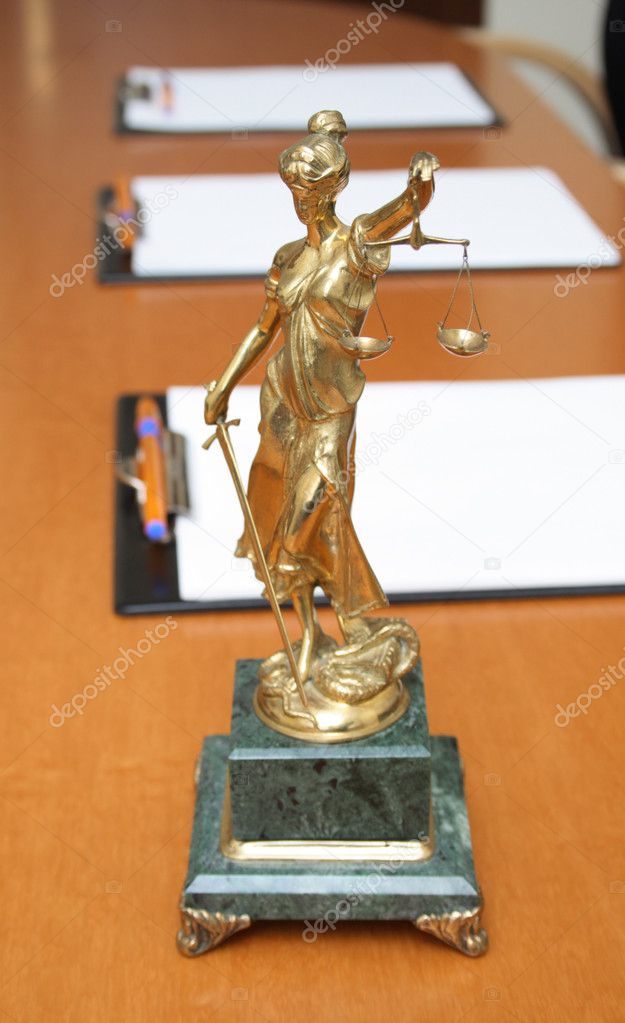 Scales of justice and blank paper on a table