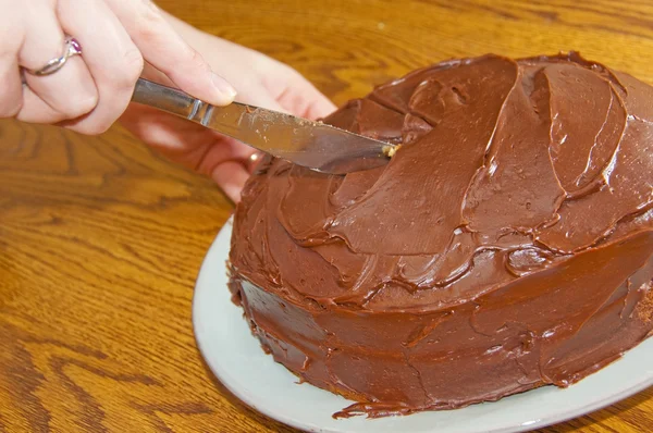 Cutting a chocolate cake — Stock Photo, Image