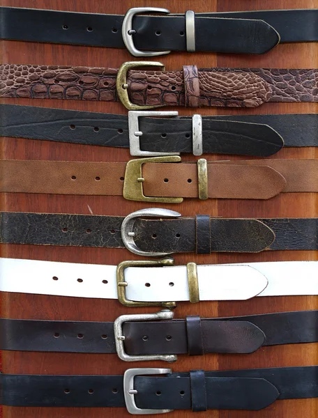 stock image Leather belts on wood background