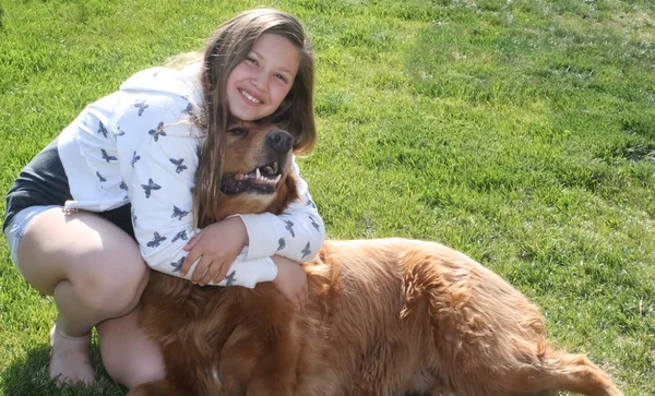 Adolescente abraçando grande cão vermelho — Fotografia de Stock