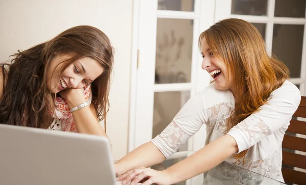 Deux jeunes femmes s'amusent devant un ordinateur portable — Photo