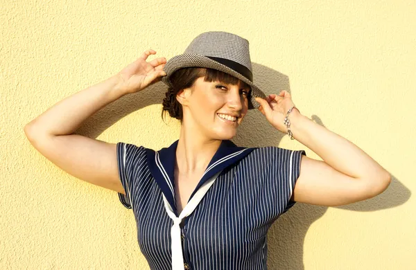 Счастливая девушка на фоне стен в шляпе — стоковое фото