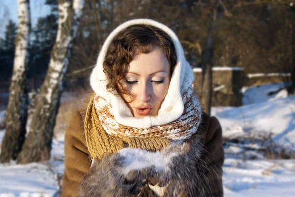 Flickan i vintern i naturen håller snön i händerna på — Stockfoto