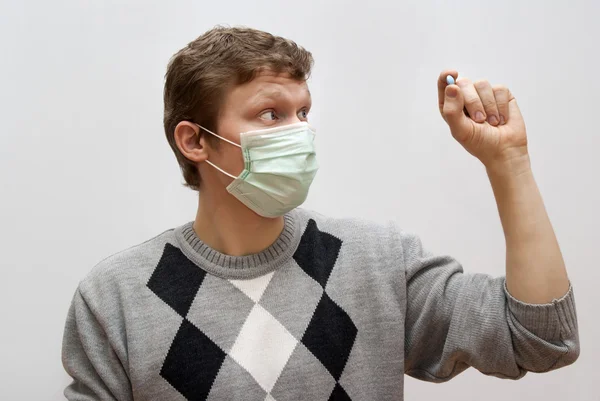 The guy in the mask considers pill — Stock Photo, Image