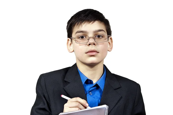 Um rapaz com óculos escreve: — Fotografia de Stock