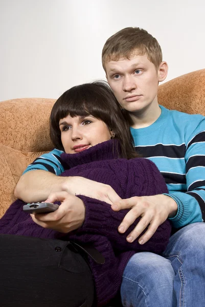 Um cara e uma menina assistindo tv — Fotografia de Stock