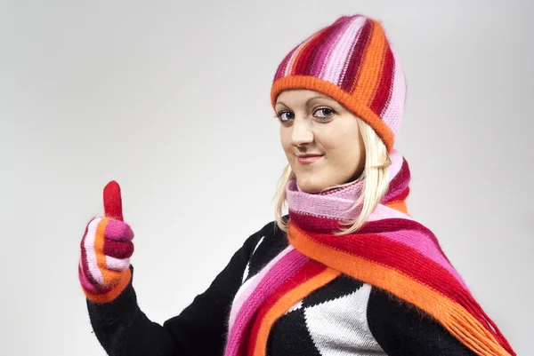 Beautiful girl in a hat and gloves shows a well- — Stock Photo, Image