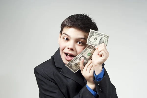 Fiú boldog monetáris jutalmak egy szürke háttér — Stock Fotó