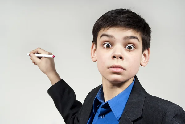 Rapaz maravilha olha com uma caneta esferográfica — Fotografia de Stock