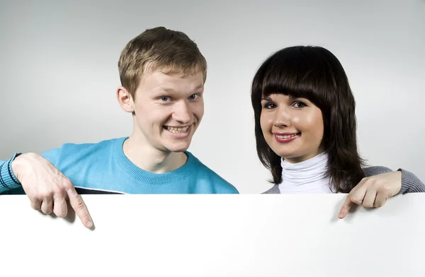 Der Mann und die Frau zeigen lächelnd in den Hintergrund — Stockfoto