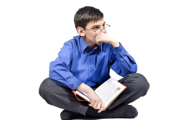 En kille sitter och håller en bok — Stockfoto