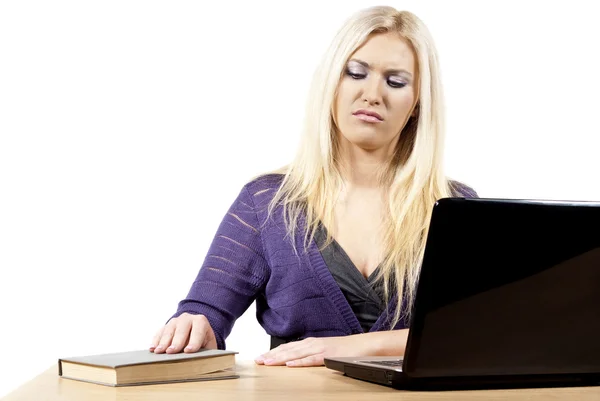 Meisje op zoek naar een laptop op de boeken — Stockfoto