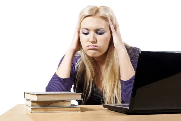 Bir dizüstü bilgisayarda kitapları kız görünüyor yorgun — Stok fotoğraf