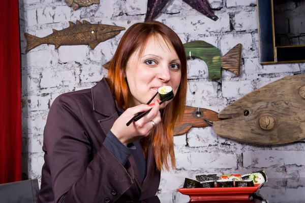 Красивая девушка ест суши — стоковое фото