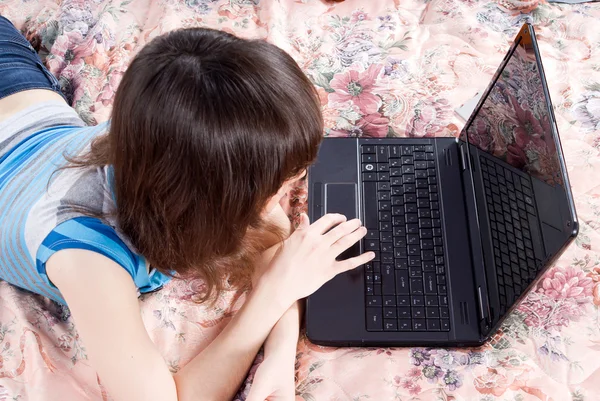 ノート パソコンとベッドの上の美しい少女 — ストック写真