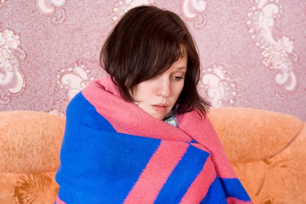 Meisje viel ziek en verpakt in een deken — Stockfoto