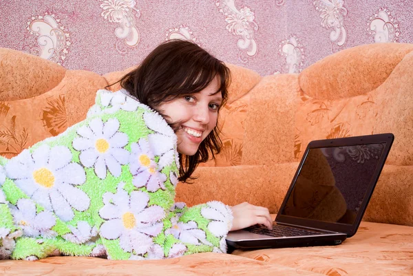 Chica en un albornoz funciona para el ordenador portátil — Foto de Stock