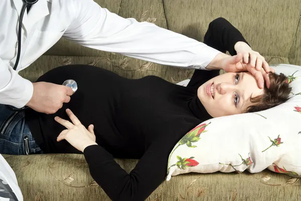 Беременная девушка лежит на диване — стоковое фото
