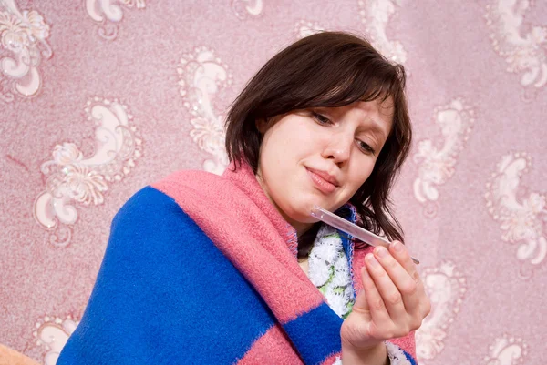 Ziek meisje thermometer in een badjas — Stockfoto