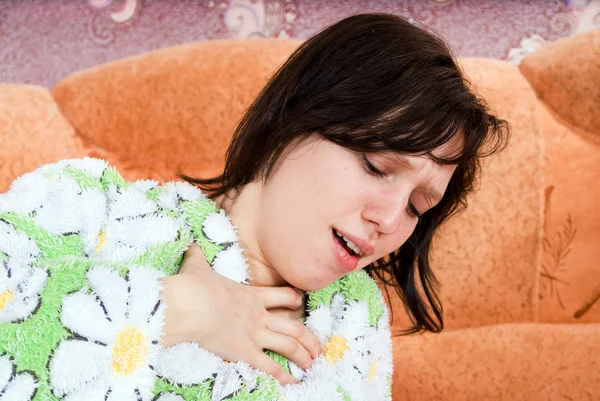 La ragazza sul divano a casa tossisce — Foto Stock