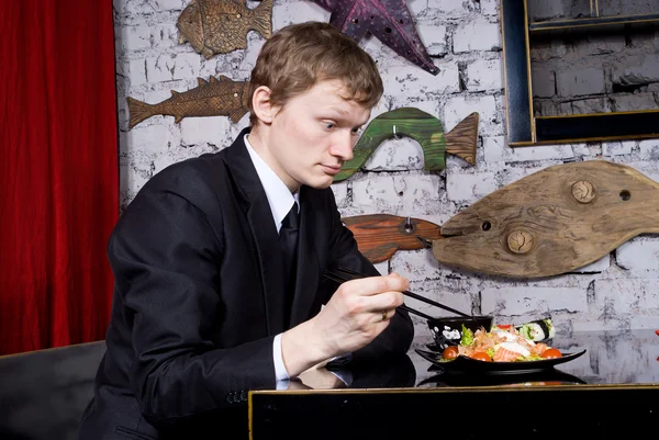 The guy takes sushi — Stock Photo, Image