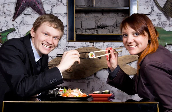 stock image The guy with the girl eat sushi