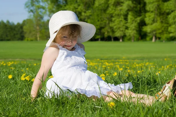 Uma menina senta-se na grama verde — Fotografia de Stock