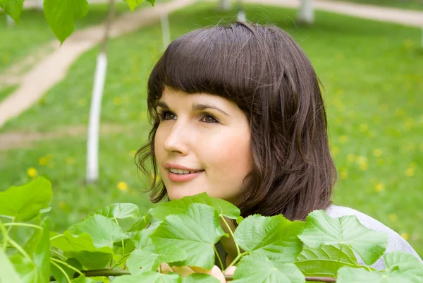Schöne Mädchen versteckt in üppigem Grün, in der Natur — Stockfoto