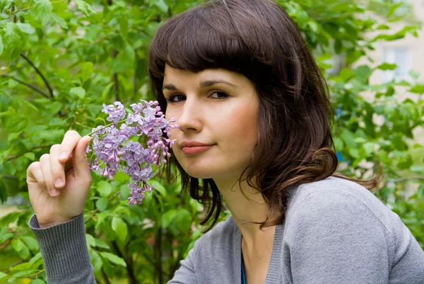 Beautiful girl keeps lilac, in nature — Stock Photo, Image