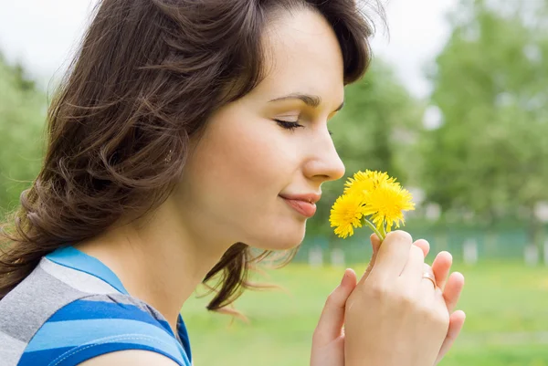 Beautiful girl sniff the flowers, in nature — Stock Photo, Image